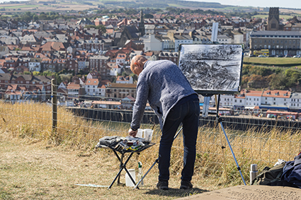 Robert on location at Whitby, North Yorkshire, drawing with charcoal mixed media – complexity simplified with focus and a keen eye for detail